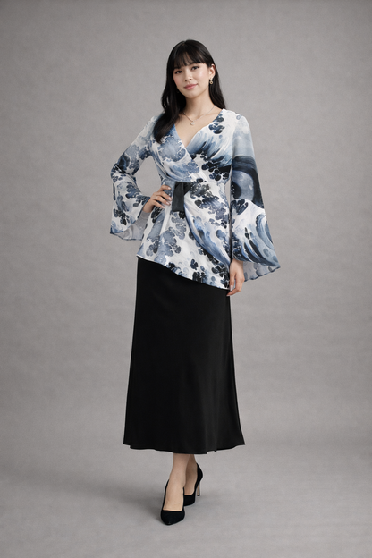 Femme portant une blouse à fleurs et une jupe noire sur fond gris
